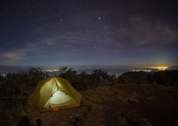 istock tent glows under a night sky full of stars. 600140678