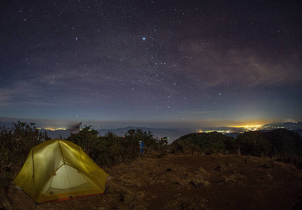 istock tent glows under a night sky full of stars. 600144068