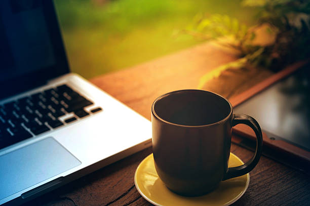 istock tablet laptop and black coffee cup on wood 600145394