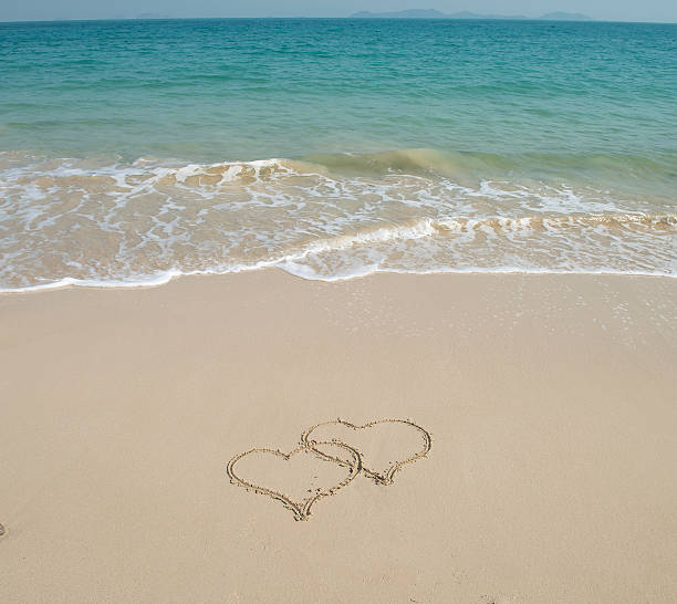 istock two hearts in sand on a beautiful beach 600149262