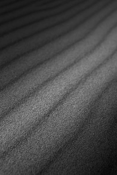 istock waves of sand formed by wind, in the dark 600153876