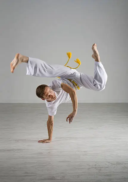 Young Man practicing Capoeira (brazilian martial Art with Elements of Dance, Acrobatics and Music).