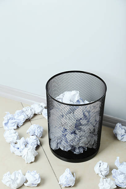 istock Office trashcan with crumpled paper balls on grey background 600154876