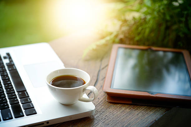 istock Laptop, tablet, smartphone and white cup coffee on wooden table. 600155358