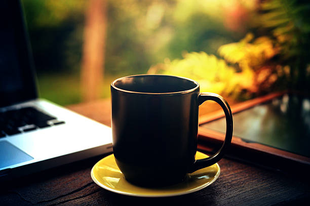 istock tablet laptop and black coffee cup on wood 600155454
