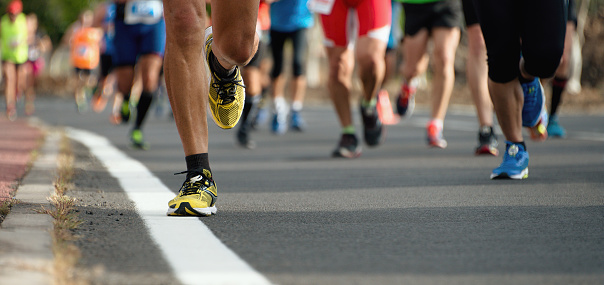 Runner leader runs ahead group of athletes marathoners