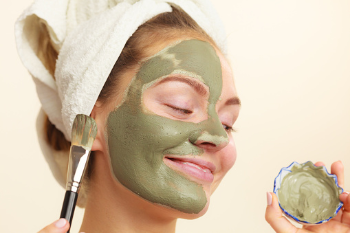 Mujer Aplicación con cepillo arcilla barro máscara de la cara photo