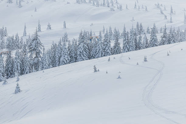 istock Ski lift with seats going over the mountain and paths 600164276