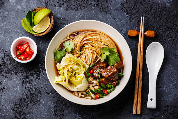 Spicy noodles in broth with Beef Spicy asian noodles in broth with Beef on dark background chopsticks photos stock pictures, royalty-free photos & images