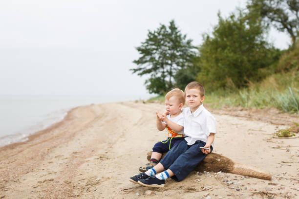 Two brothers sitting on a bank of the river