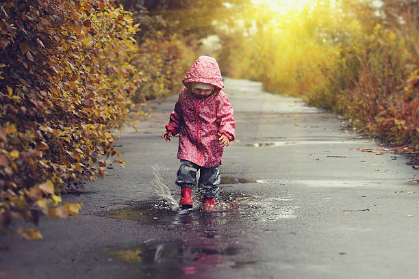 istock Toddler girl jumping in puddles after rain 600166314