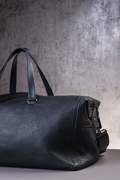 istock Black leather traveling bag, over the concrete wall background 600166356