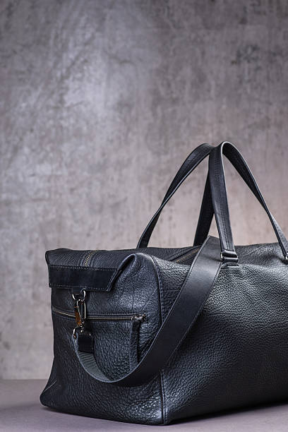 istock Black leather traveling bag, over the concrete wall background 600166838