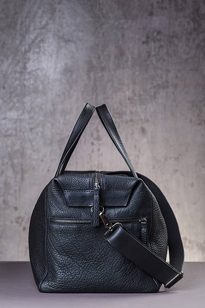 istock Black leather traveling bag, over the concrete wall background 600166932