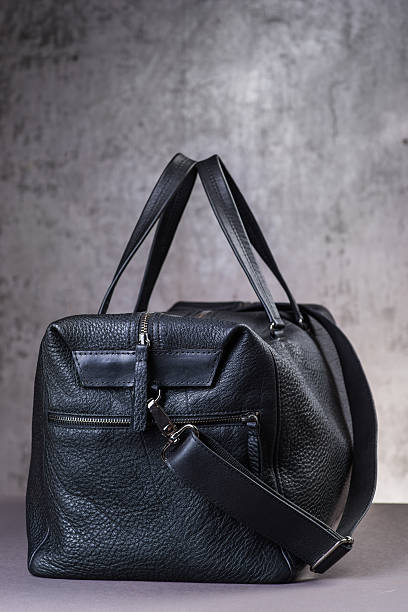 istock Black leather traveling bag, over the concrete wall background 600167056