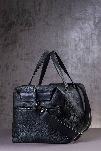 istock Black leather traveling bag, over the concrete wall background 600167272