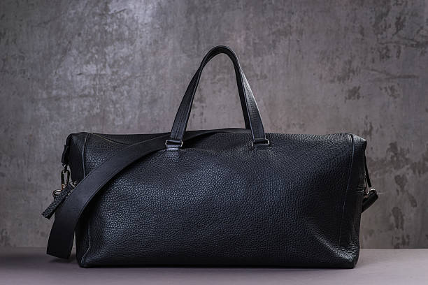 istock Black leather traveling bag, over the concrete wall background 600167566