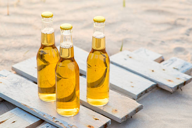 istock Three beer bottles standing on the rustic wooden board 600167668