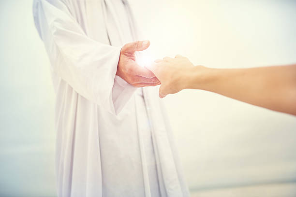 Come near so I can touch you Shot of Jesus standing with his hand outstretched toward a follower on a bare landscape jesus christ stock pictures, royalty-free photos & images