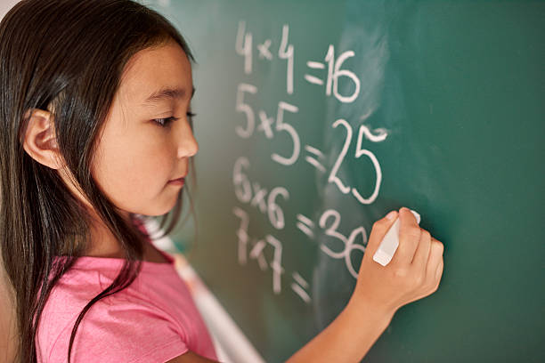 focus fille essayant de résoudre l’équation mathématique - blackboard child thinking little girls photos et images de collection