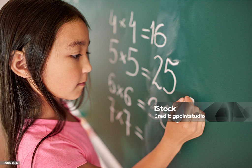 Focus girl trying to solve mathematical equation Mathematics Stock Photo