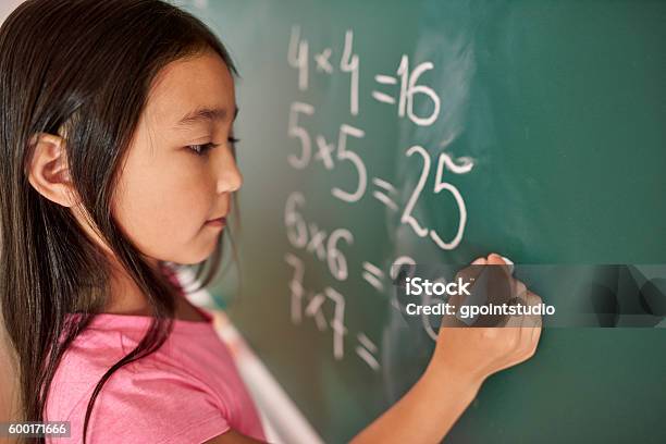 Focus Girl Trying To Solve Mathematical Equation Stock Photo - Download Image Now - Mathematics, Child, Chalkboard - Visual Aid