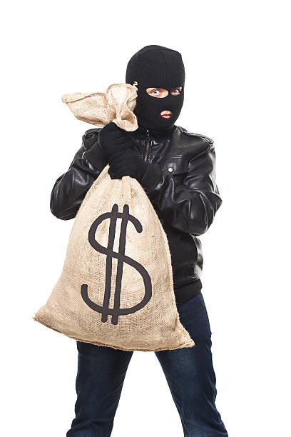 istock Thief   and full bag of money 600175840