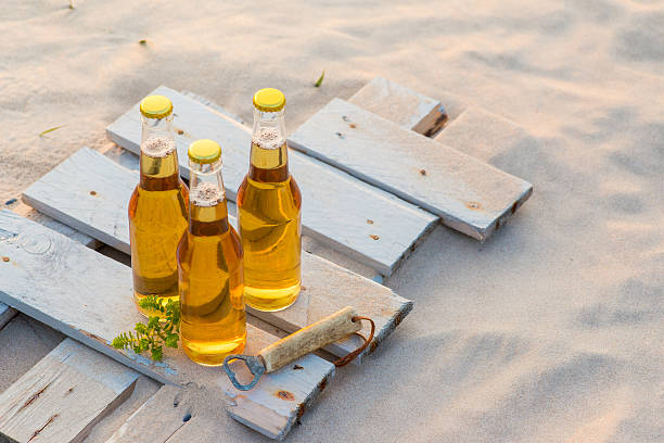 istock Three beer bottles standing on the rustic wooden board 600372144
