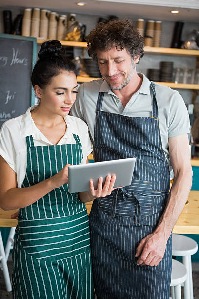 istock Waiter and waitress discussing over digital tablet 600372504