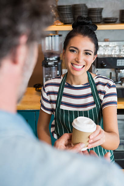 istock Waitress giving cup of coffee to customer 600372614
