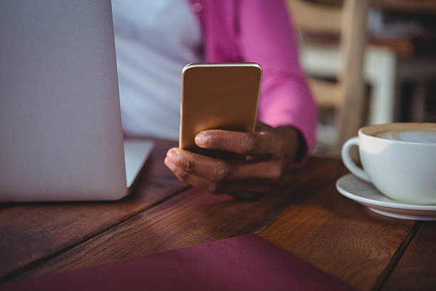 istock Woman using mobile phone in cafeteria 600373102
