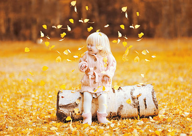 istock Happy child having fun playing with flying yellow leaves autumn 600374232
