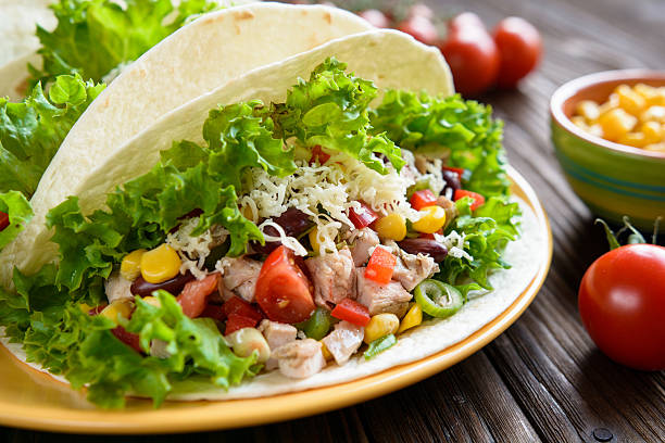 istock Mexican tacos with meat, beans, lettuce, corn, onion and tomato 600375132