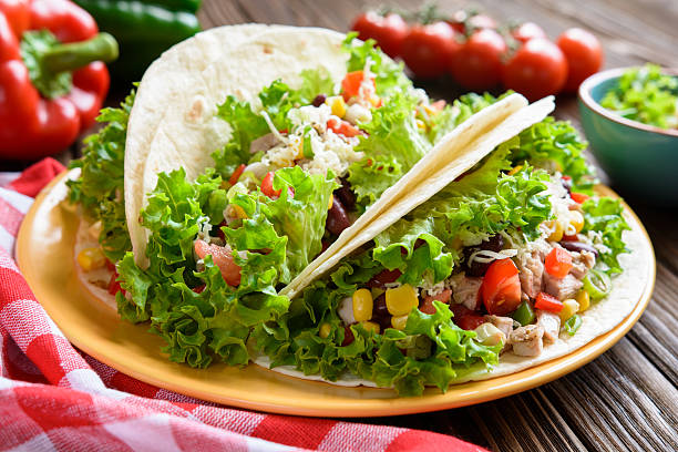 istock Mexican tacos with meat, beans, lettuce, corn, onion and tomato 600375228