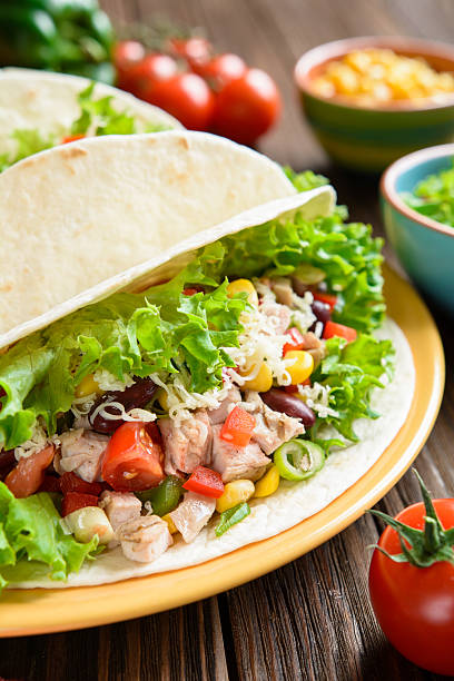 istock Mexican tacos with meat, beans, lettuce, corn, onion and tomato 600375336