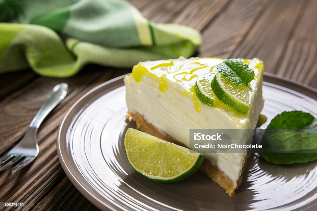 No-bake cheesecake with lime, mascarpone, whipped cream and mint Fresh no-bake cheesecake with lime, mascarpone, whipped cream and mint leaf on a wooden background Lime Stock Photo