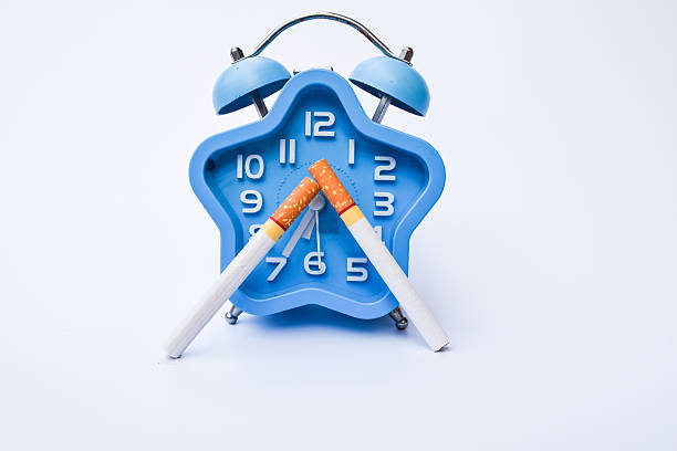 cigarette and alarm clock isolated on white background,world no tobacco day concept