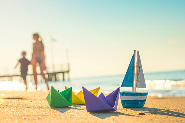 bateaux en papier, bateau en bois et piétons à la plage - Photo