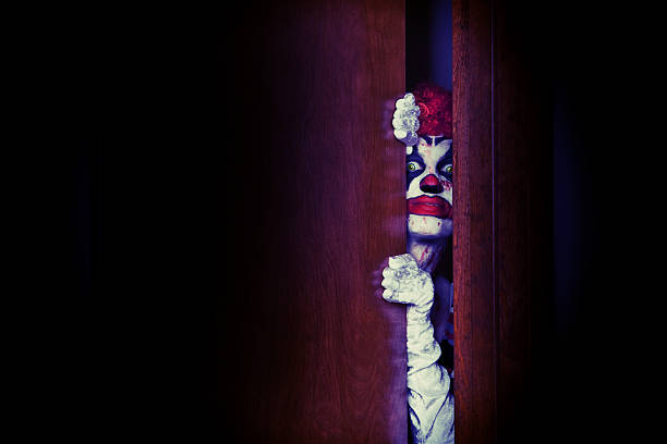 Creepy Clown In The Closet A creepy clown peeking though a closet door. creepy stalker stock pictures, royalty-free photos & images