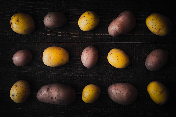 istock Pattern of raw potatoes on the old wooden background 600386110