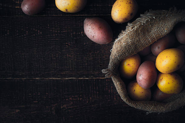 istock Potatoes mix in canvas bag on wooden table top view 600386368