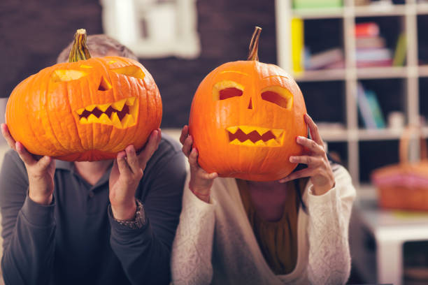istock Man and woman having fun with Halloween pumpkin 600388542