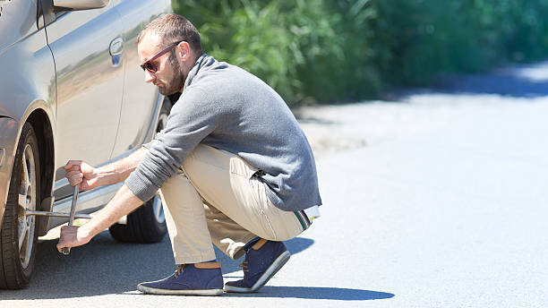 istock Unhappy man repairing a tire 600388672