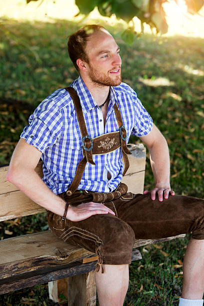 istock young man in traditional bavarian clothes sitting on bench 600391132