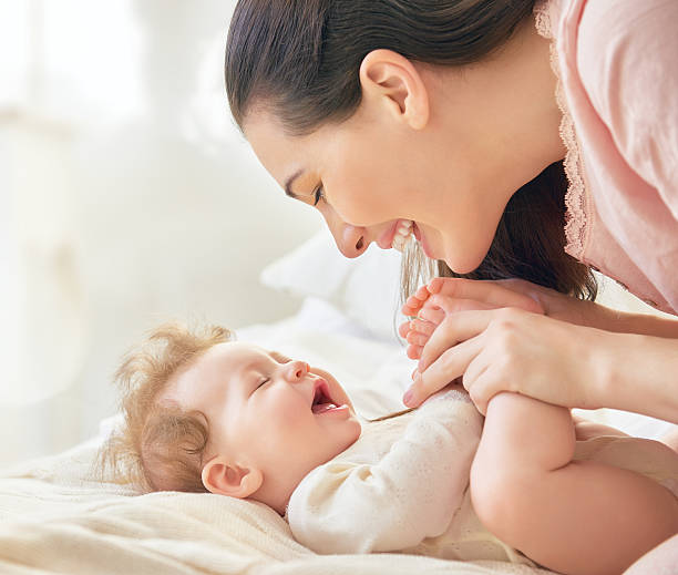 istock mother playing with her baby 600393182