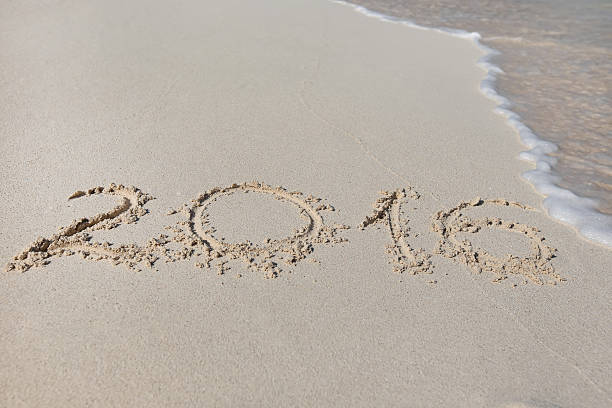 istock Inscription 2016 on sandy beach with wave's foam 600393500