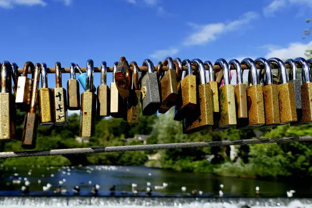 A row of love locks fixed on a bridge over the river Wye.