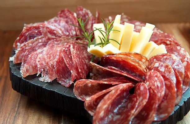 Salami and cheese on wooden board. Appetizers.