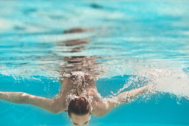 istock Swimming young woman underwater in pool 600401140