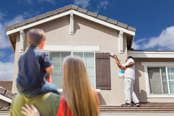 Young Family Watching House Get Painted by Painter